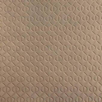Leather rug with repeating geometric diamond pattern featuring central circles and vertical lines in a mottled tan color.
